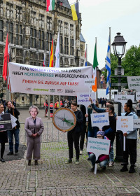 Demonstrierende halten Banner und Plakate hoch für die Menschenrechte, die EU-Lieferkettenrichtlinie und den Umweltschutz