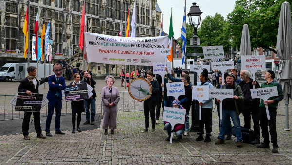 Demonstrierende halten Banner und Plakate hoch für die Menschenrechte, die EU-Lieferkettenrichtlinie und den Umweltschutz